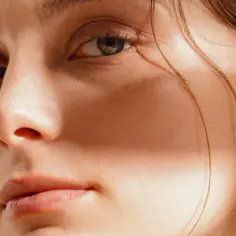 Delikatna skóra i spojrzenie modelki, podkreślające naturalne piękno. Idealny kadr dla branży beauty.